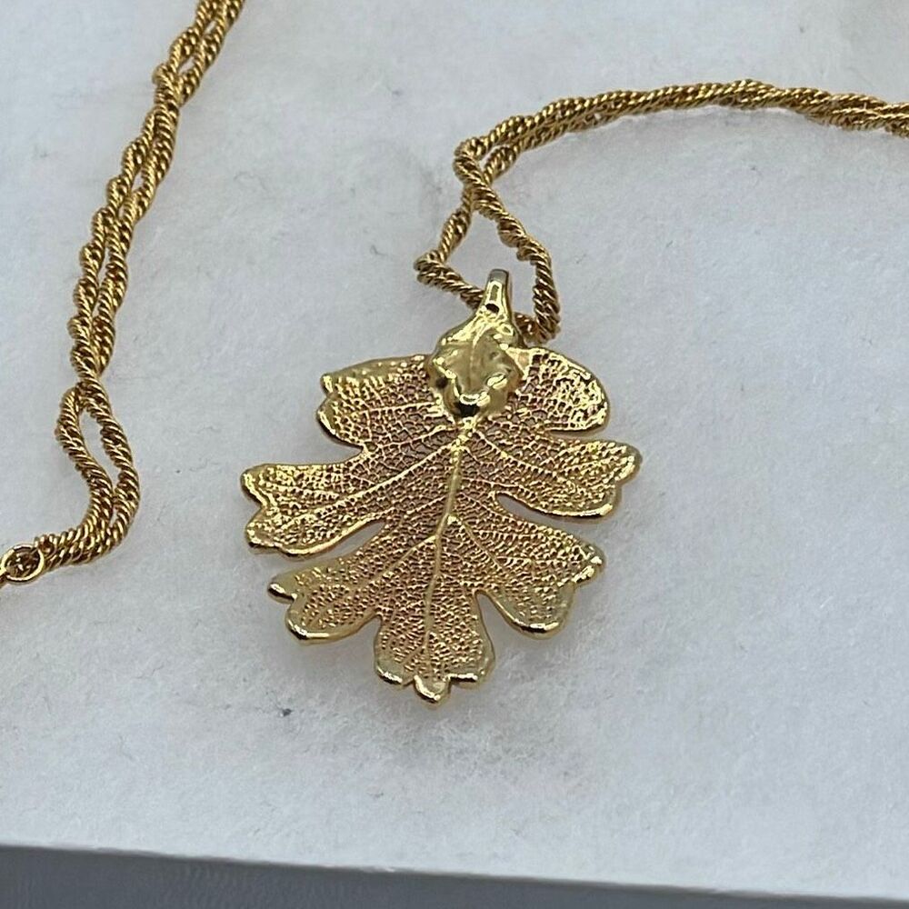 Vintage gold tone oak leaf pendant and 25” approximately chain.